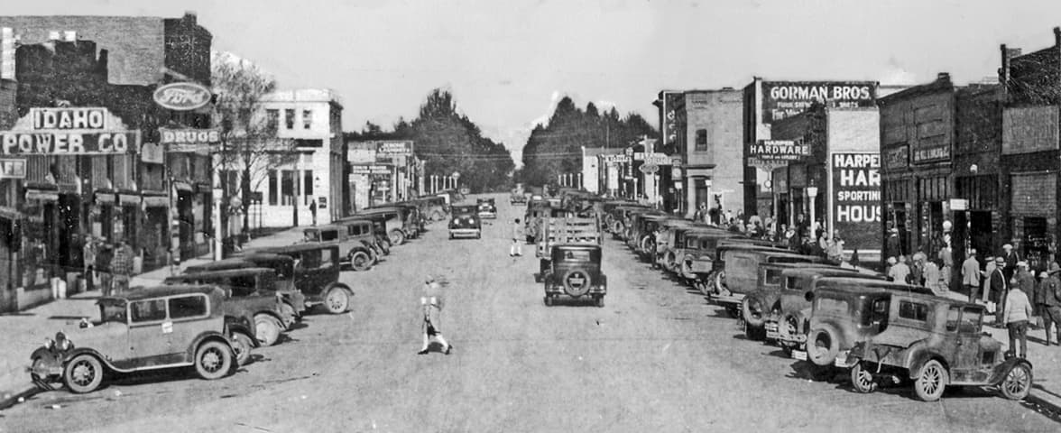 Main Street in downtown Jerome, Idaho, generations ago: cars parked along both curbs and hand-painted storefront signs